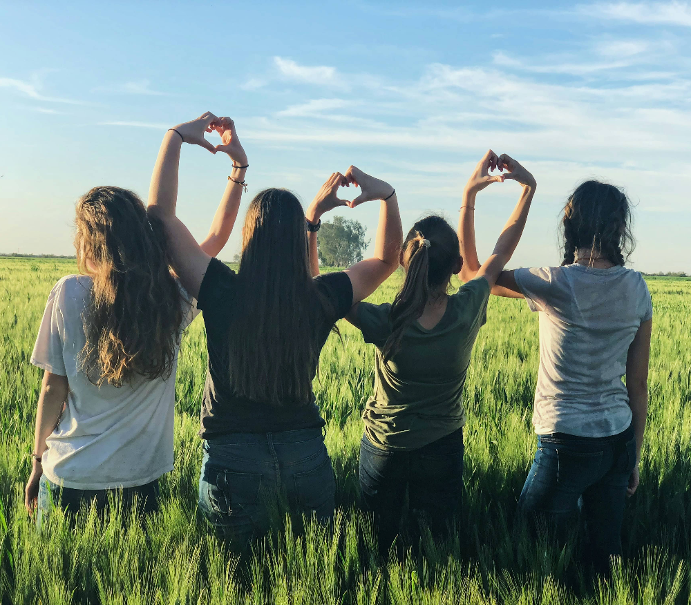 young-women-forming-hearts-with-linked-hands