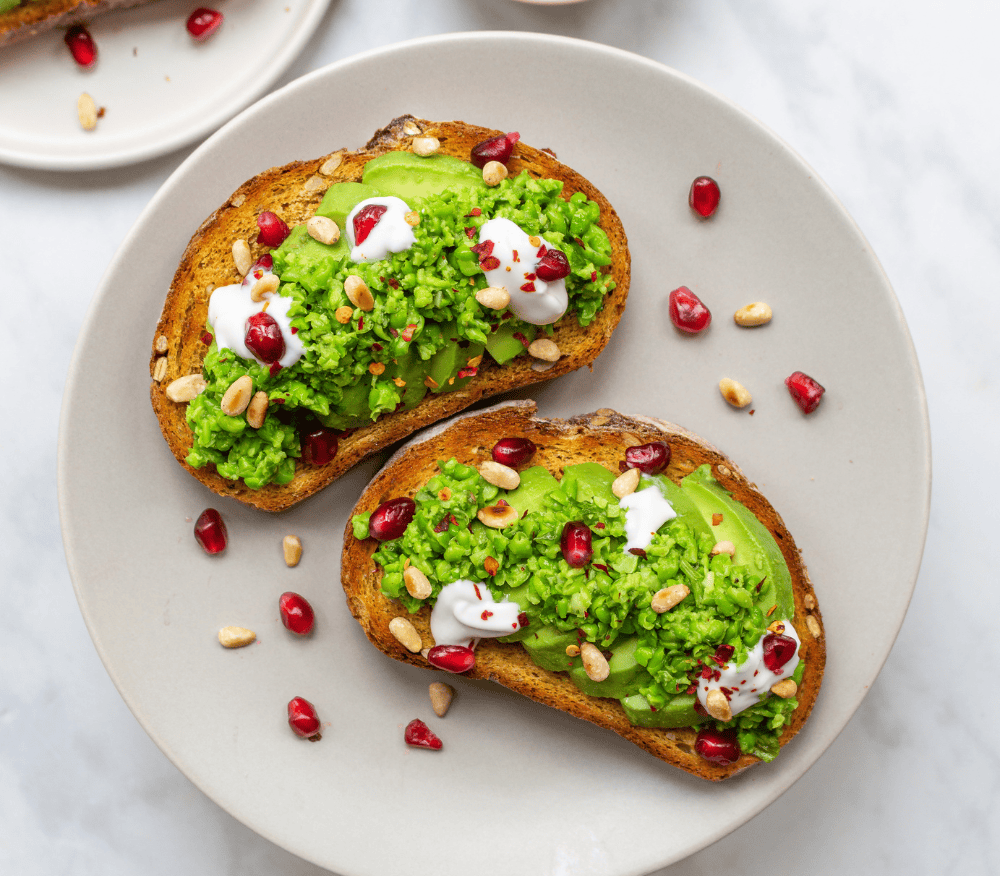 A plate with two slices of smashed pea and avocado on toast