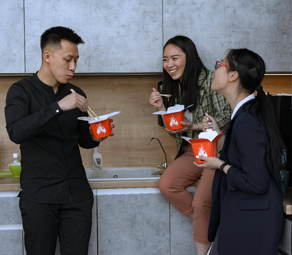 three-people-enjoying-takeaway-from-boxes
