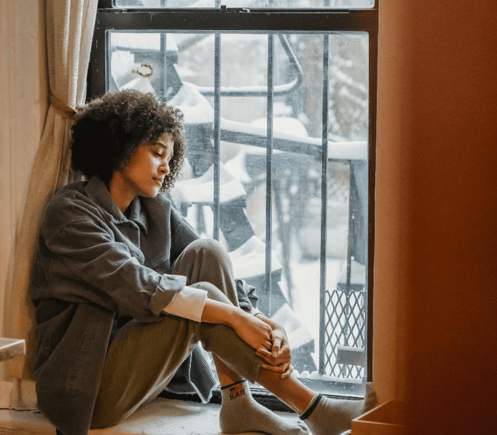 sitting at a window in pain