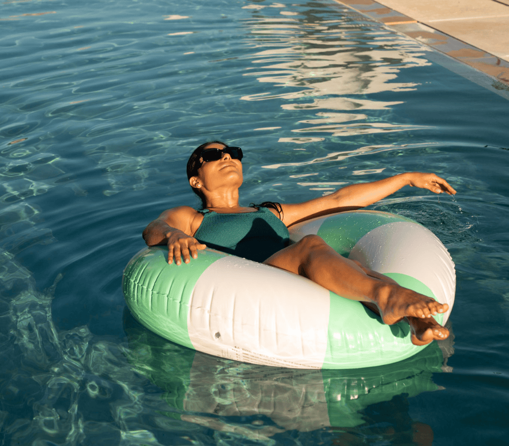 Lady laying in a rubber ring in swimming pool