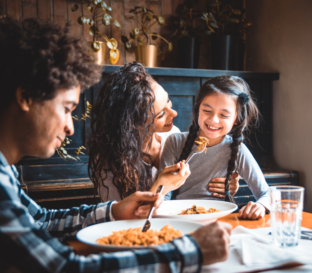 child eating dinner with parents at the dinner table