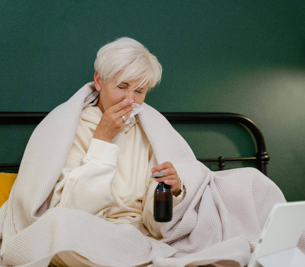 a-woman-blowing-her-nose-in-bed