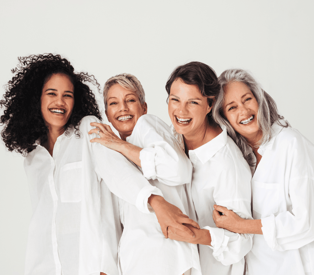 Four women in white shirts smiling