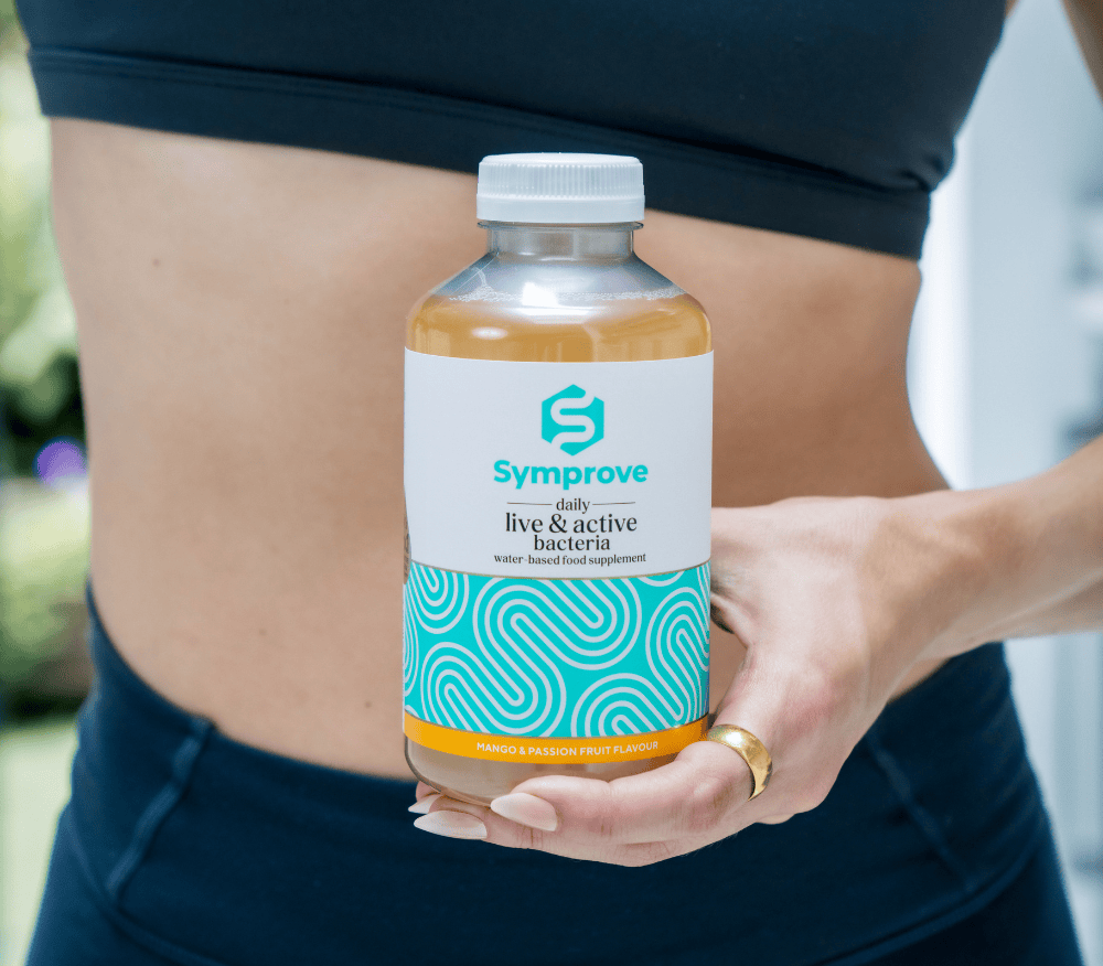 A bottle of Symprove held in front of a stomach