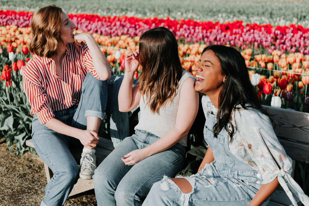 three-friends-enjoying-afternoon-sun-in-a-field-of-flowers