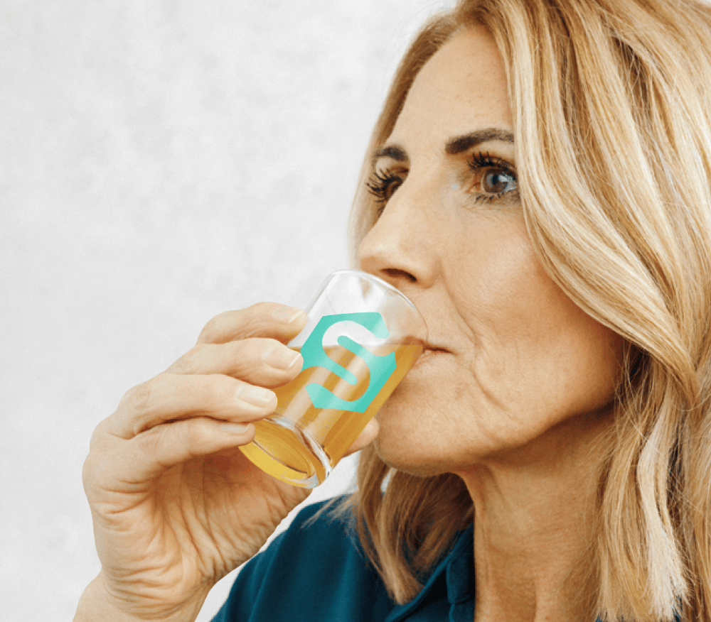 Lady drinking her morning shot of Symprove