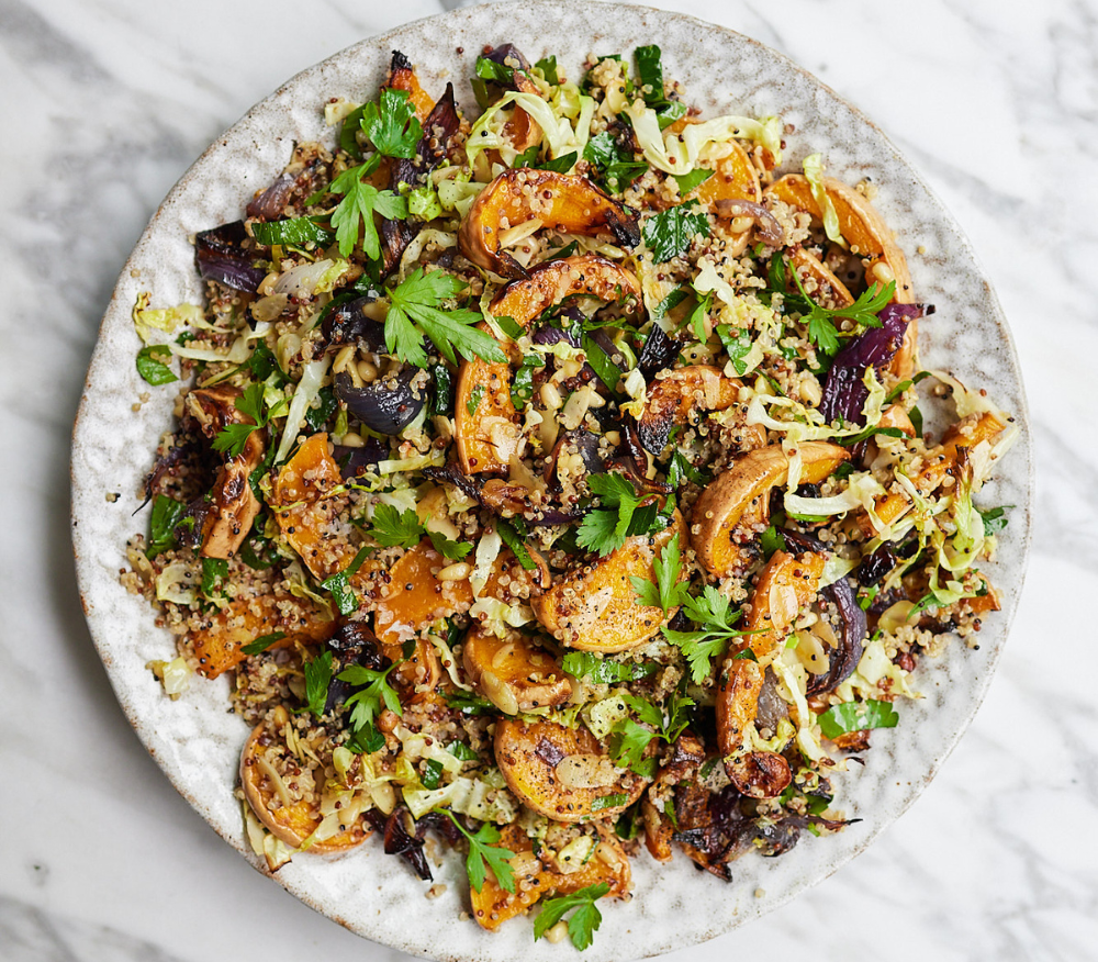 A plate loaded with Ella Mills' warm roasted squash, almond and quinoa salad with pine nuts and garlic
