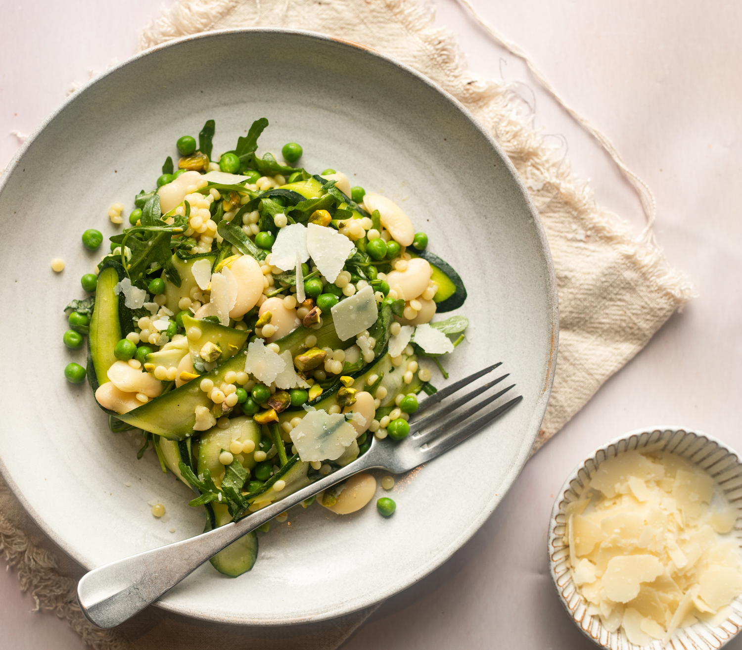 Gut loving grain bowl with butterbeans, courgette, garden peas, pistachios, rocket and cous-cous